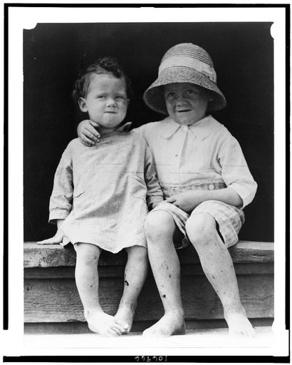 Two children, seated on step, facing front