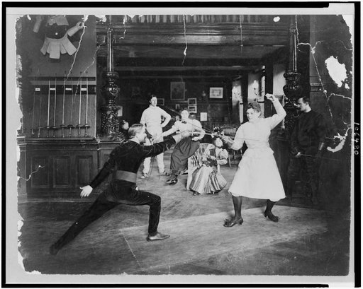 Man and woman fencing