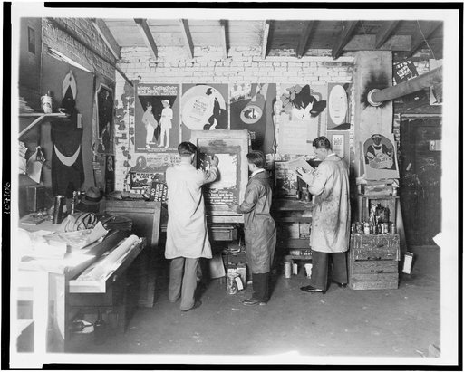 Three men working in print shop, numerous posters displayed in background, Washington, D.C.(?)