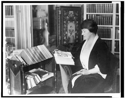 Mary Roberts Rinehart, three-quarter length, seated, facing left, reading book
