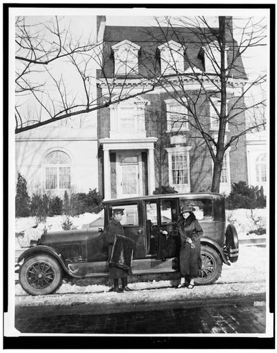 Mary Roberts Rinehart, full-length, getting into automobile, facing slightly left, with chauffer standing alongside