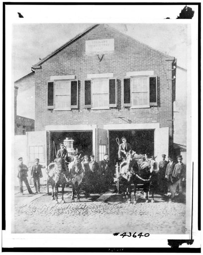 Fireman with firefighting equipment in front of the Vigilant Firehouse, 1066 Wisconsin Avenue Northwest, Washington, D.C.