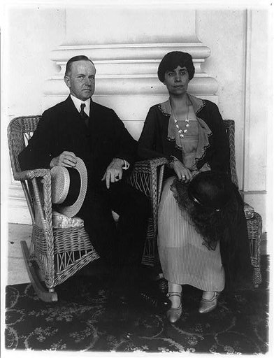 Calvin Coolidge and his wife, full-length portrait, seated in wicker armchairs