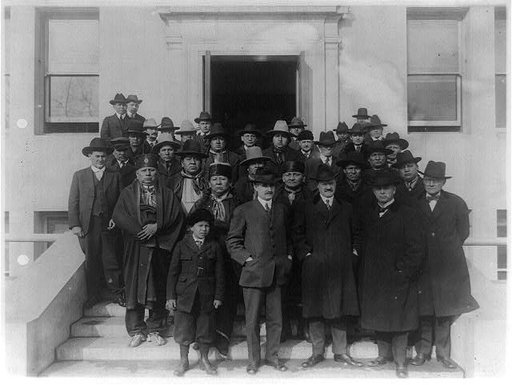 The Osage Council, with other Osage Indians, who came to Washington in connection with gas and mineral rights on the Osage Nation in Oklahoma. Commissioner of Indian Affairs Cato Sells, Assistant Commissioner E.B. Meritt and Superintendent of the Osage Nation J. George Wright are in foreground