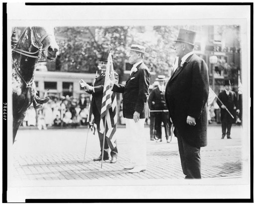 Woodrow Wilson, holding U.S. flag, in parade, on Preparedness Day, Washington, D.C.