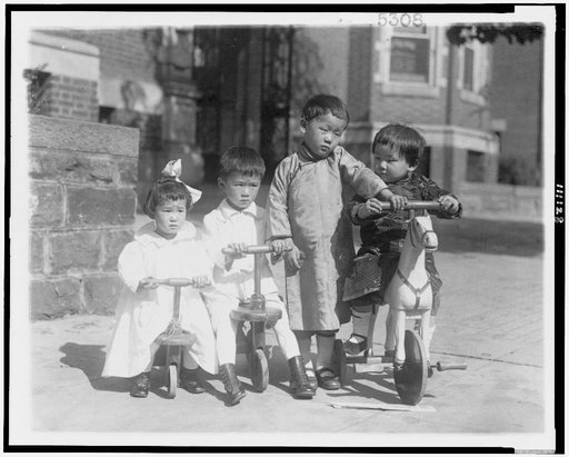 Four Oriental children, with small bicycles