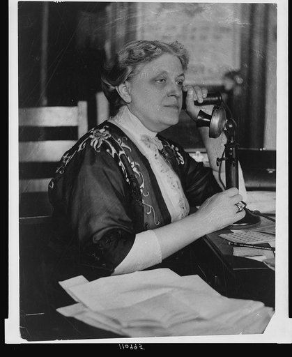 Carrie Chapman Catt, half-length portrait, seated, facing left, on telephone