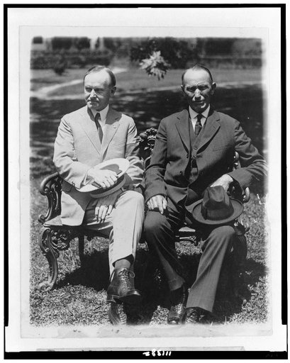 President Coolidge and his father, full-length portraits, seated on lawn chair