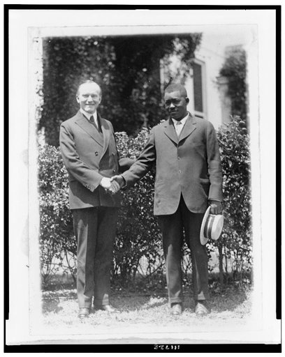 President Coolidge and Thomas Lee, Mississippi River hero, full-length portrait, standing, shaking hands