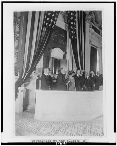 President Calvin Coolidge and First Lady Grace Goodhue Coolidge with Librarian of Congress Herbert Putnam and others during the dedication of the "shrine" for public display of the Declaration of Independence and the Constitution in the Great Hall of the Library of Congress