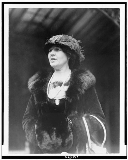 Aurelia H. Reinhardt, half-length portrait, wearing fur-trimmed coat and muff