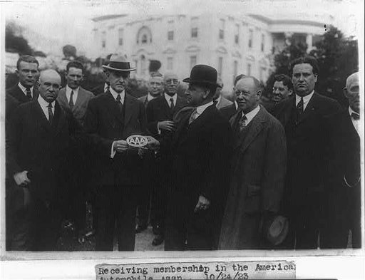 Charles A. Frazer presents President Coolidge with an American Automobile Association emblem before a small gathering of AAA members on the White House lawn