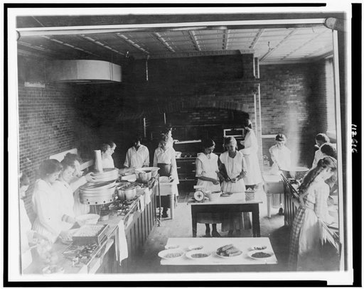 Women canning food in industrial kitchen in a school(?) during war