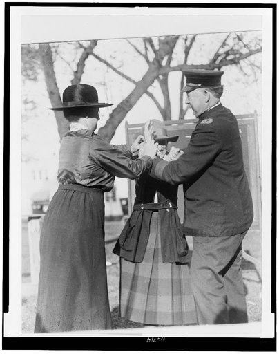 Training a policewoman--Inspector Cross and Miss Clark, veteran policewoman, are shown demonstrating the correct way to handcuff a prisoner