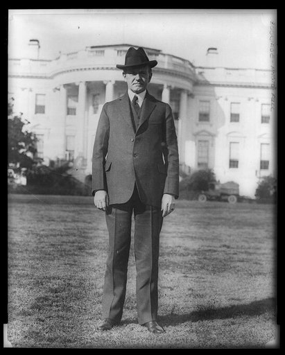 President Coolidge, full-length portrait, standing on south lawn of White House, facing front