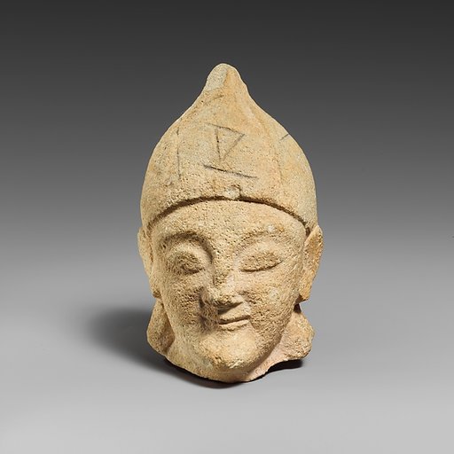 Limestone head of a beardless male with a helmet of Greek type