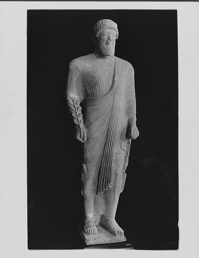 Limestone votary of a bearded male in Greek dress with a wreath