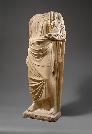 Limestone statue of a man holding a mask in the form of a bull's head