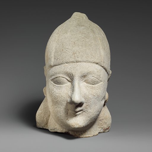 Limestone head of a beardless male wearing a conical helmet