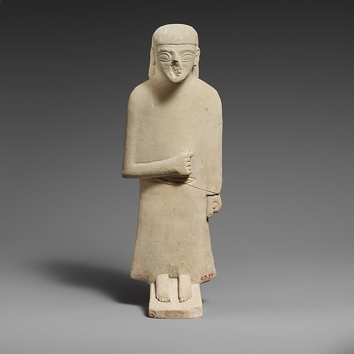 Limestone statuette of a male votary with a long garment and a plain headdress