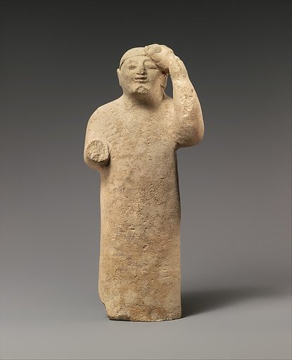 Limestone figure holding a mask