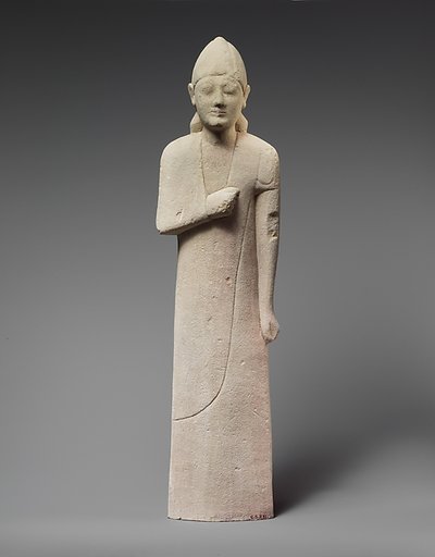 Limestone statuette of a beardless male votary with a conical helmet