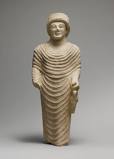 Limestone statue of a male votary holding a bird in the left hand