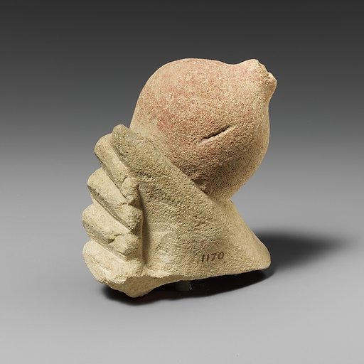 Limestone hand holding a pomegranate