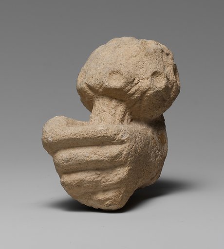 Limestone statue fragment of a left hand holding a bunch of daisies