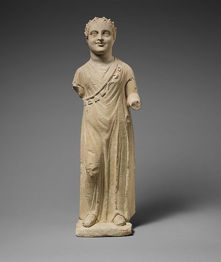 Limestone statuette of a boy with a chain of amulets