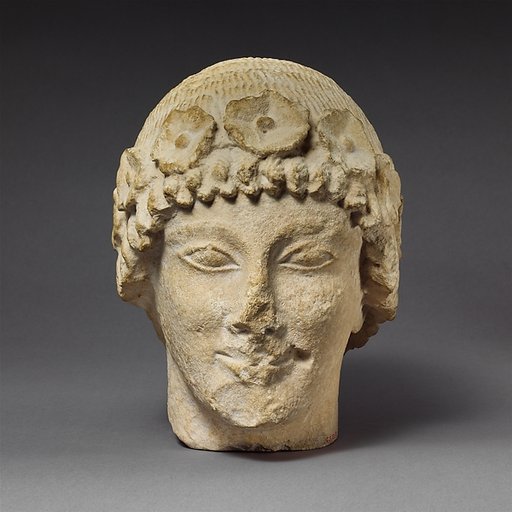 Limestone beardless male head with a wreath of rosettes