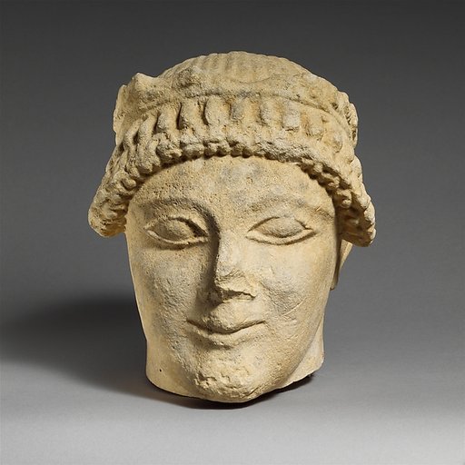 Limestone head of a beardless male votary with a wreath of leaves