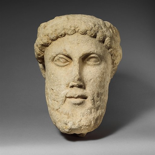 Limestone head of a bearded male with a wreath of leaves