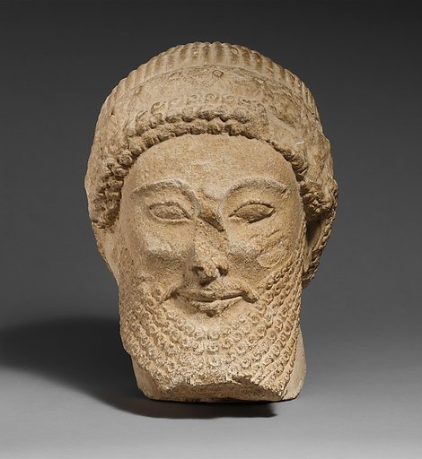 Limestone head of a bearded male with a wreath of flowers