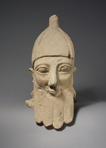 Over-lifesize bearded head wearing a conical helmet
