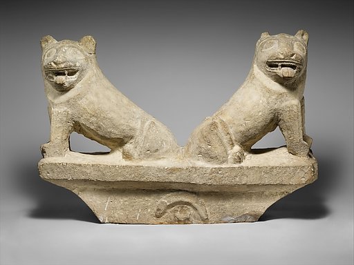 Limestone finial of a funerary stele with two seated lions