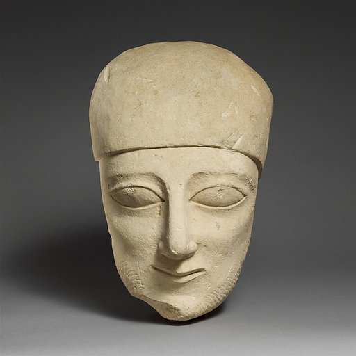 Fragment of a limestone head of a bearded male with a plain headdress