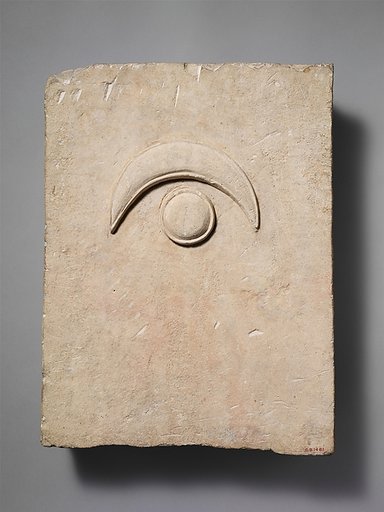 Fragment of a limestone funerary stele with a disk and a crescent