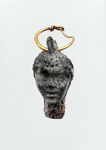 Gold earring with a glass pendant in the shape of a Black African’s head