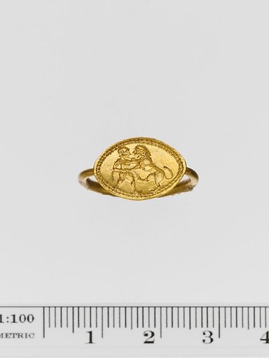 Gold ring engraved with a warrior and a lion