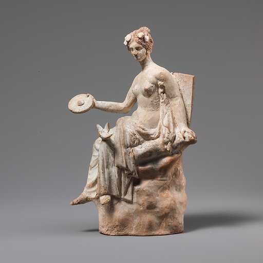 Terracotta statuette of Aphrodite seated on a rock