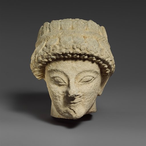 Limestone head with of a beardless male with a wreath of leaves