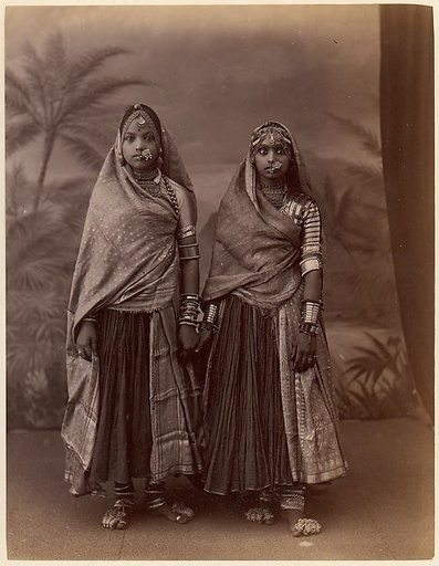 [Two Hindu Women in Elaborate Jewelry, Before Studio Backdrop with Palm Trees]