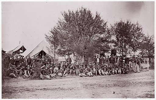 [Unidentified Company of Soldiers at Ease, Seated on Ground in Tented Camp]