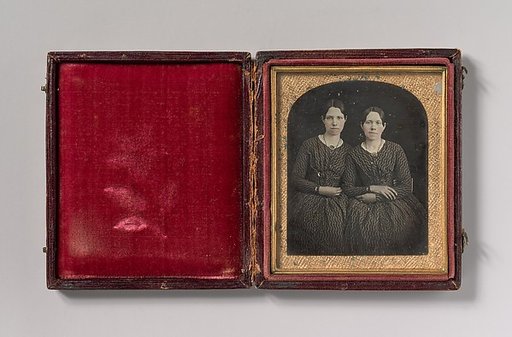 [Two Seated Young Women Identically Dressed]