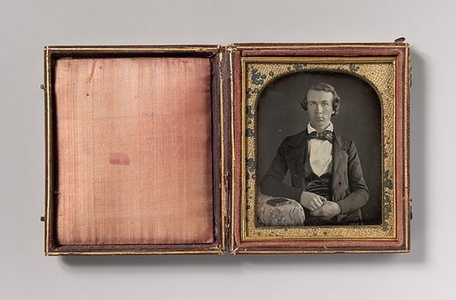 [Seated Young Man Resting Arm on Table Beside Daguerreotype Case]