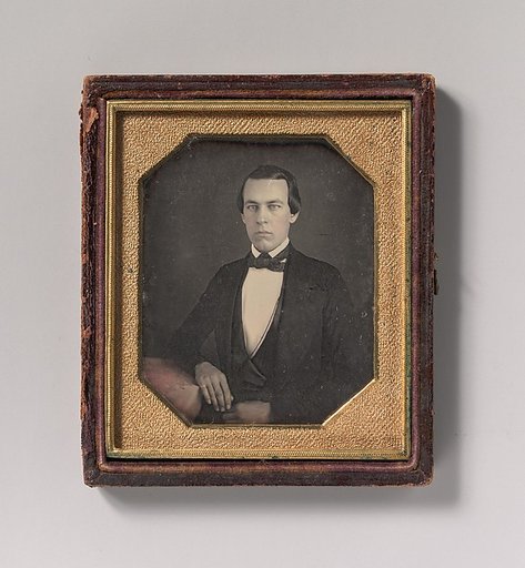 [Seated Young Man with Arm Resting on Table]