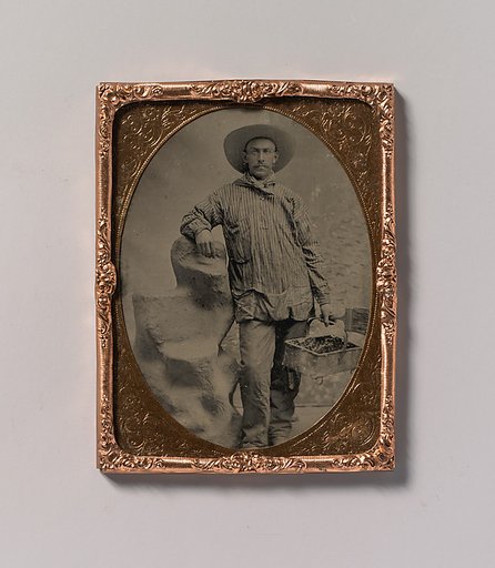 [Workman Holding Brush and Rectangular Tray, Arm Resting on Fake Rock]