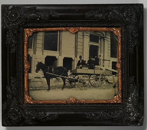 [Three Men Seated in a Horse-Drawn Buggy in Front of a Building Under Construction]