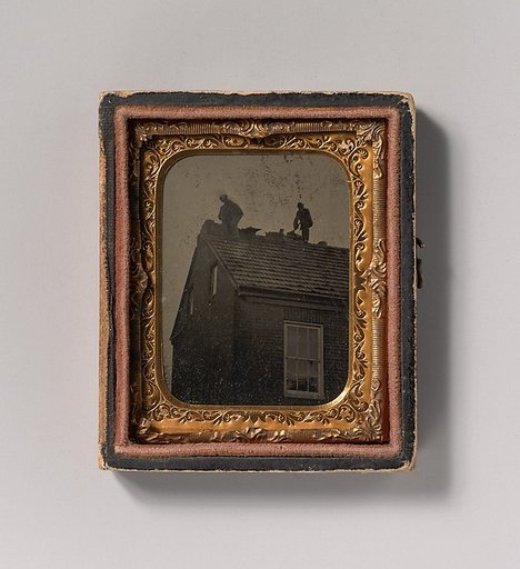 [Two Roofers Working Atop a Building]